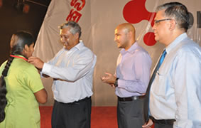 AJ Johnpillai, Group Director of Brandix presents an identification card to an associate at the ceremonial presentation of identification cards to associates of Brandix Lingerie. Dave Ranasinghe, Director (extreme right) and Rajiv Malalasekera, CEO (2nd from right) of Brandix Lingerie are also in the picture.