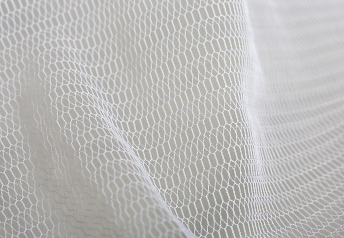 Warp-knitted tulle pattern produced with monofilament yarns on an HKS 3-M. © Karl Mayer