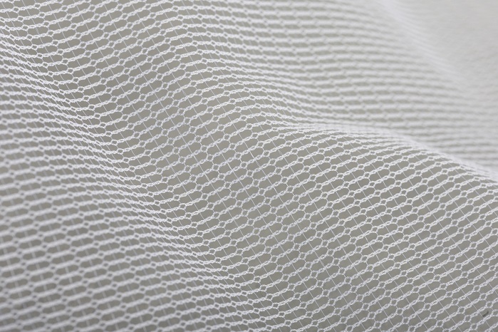 Warp-knitted tulle pattern produced with monofilament yarns on an HKS 3-M. © Karl Mayer