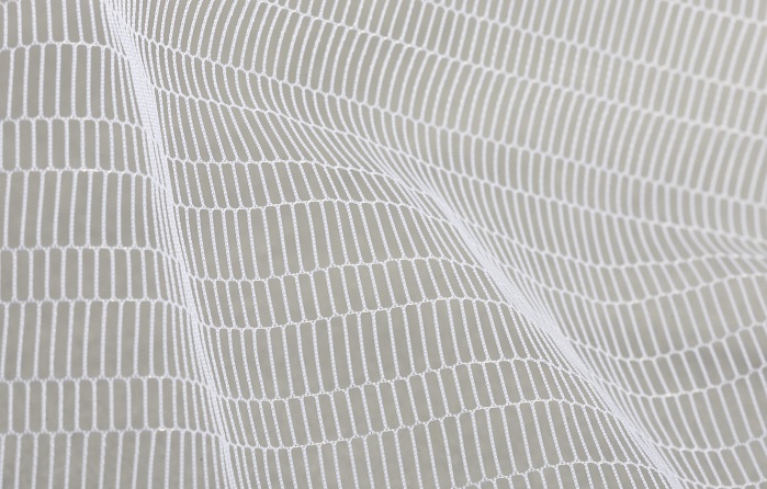 Warp-knitted tulle pattern produced with monofilament yarns on an HKS 3-M. © Karl Mayer