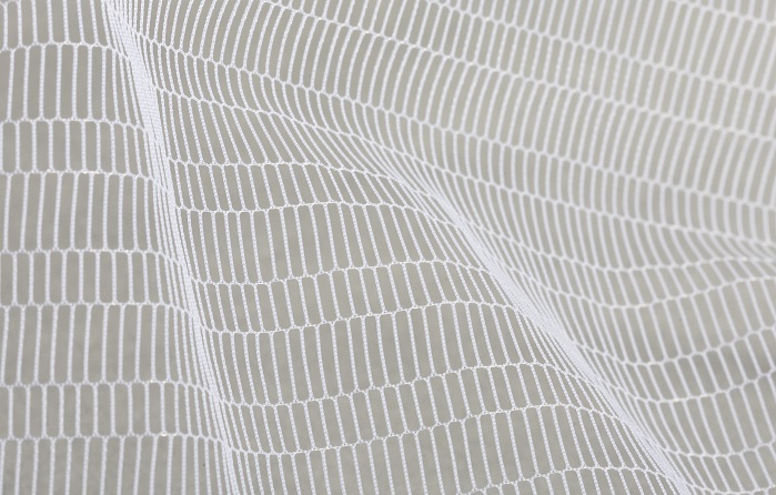 Warp-knitted tulle pattern produced with monofilament yarns on an HKS 3-M. © Karl Mayer
