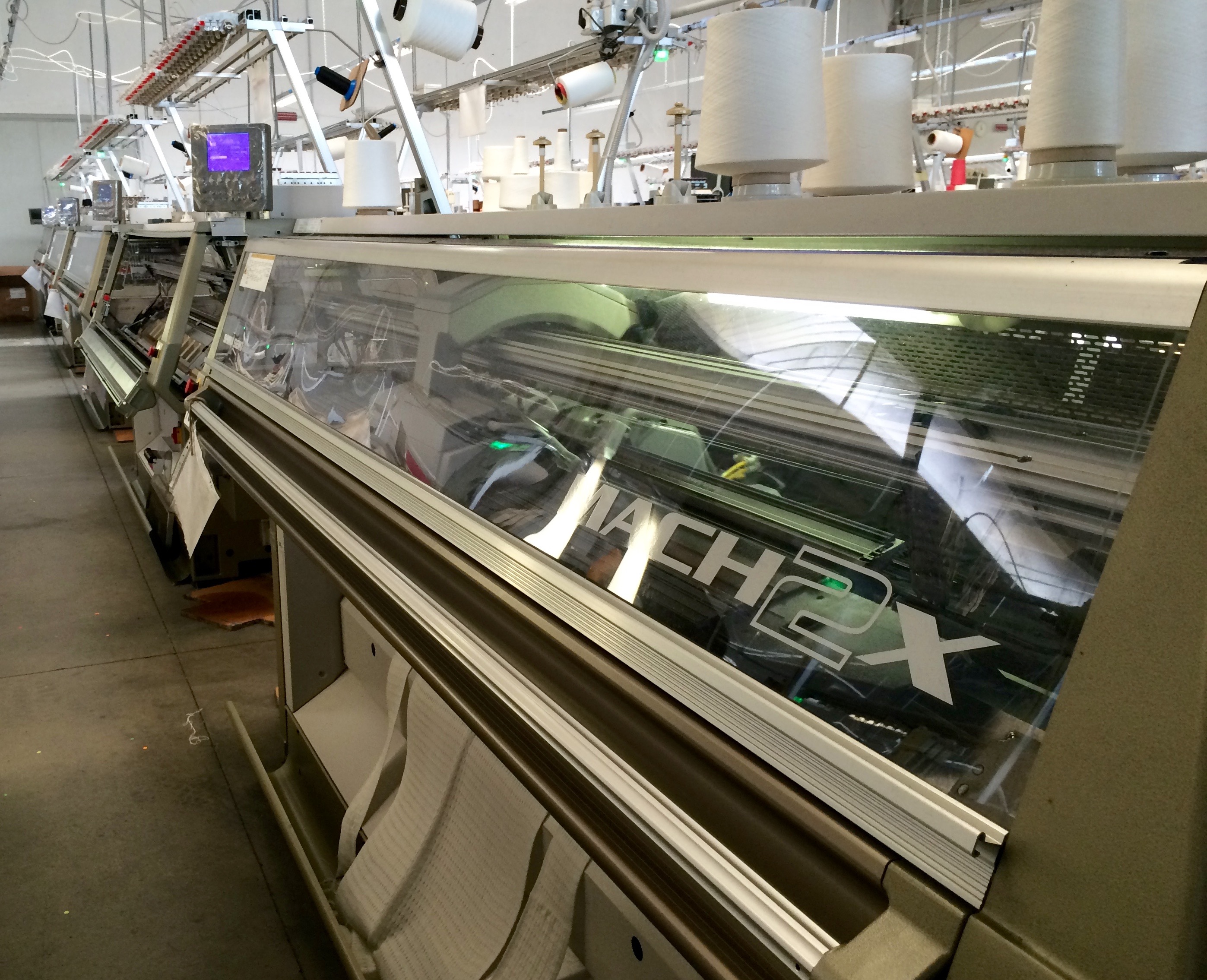 Shima Seiki MACH2X WHOLEGARMENT knitting machines in action at MIND Srl. 