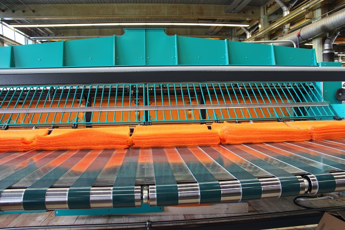 Laying table with conveyor belt and finished piles of sacks. © Karl Mayer