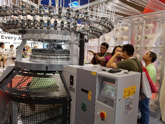 Prospective buyers inspect the OV 3.2 QCe interlock machine. © Mayer & Cie.