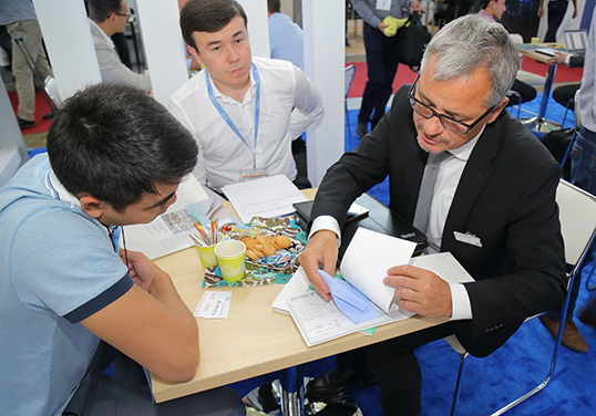 Circular knitting machine specialist Timo Schramm in a sales discussion at the CAITME. © Mayer & Cie.