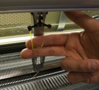 Spliced yarns passing through yarn carrier