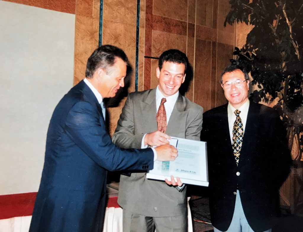 Rainer Mayer (left) and Peter Mayer (right) presenting Fernando FerradÃ¡s in 1995 with a certificate to mark 35 years of collaboration with the company’s Argentine agents Dimatex. © Mayer & Cie.